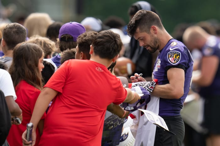 Justin Tucker signs autographs at training camp.